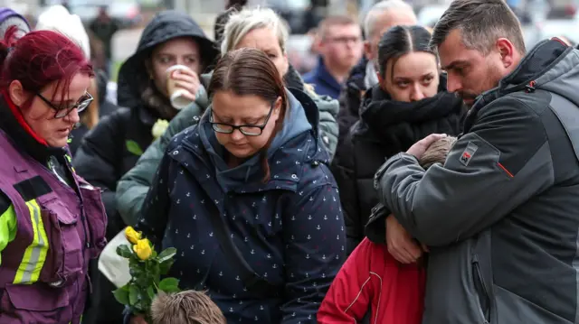 People gather at the official mourning site in front of St. John's Church to pay their respects after a car attack at a Christmas market in Magdeburg, Germany.