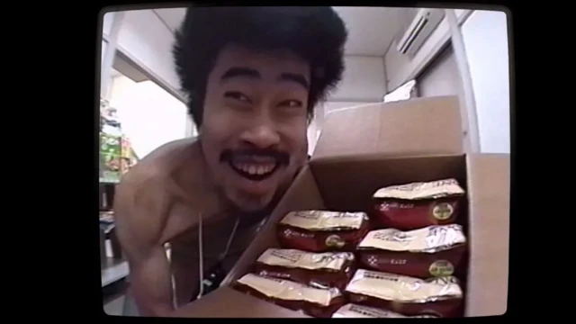 ناسوبی در حالی که می‌خندد جعبه مواد غذایی را جلوی دوربین گرفته