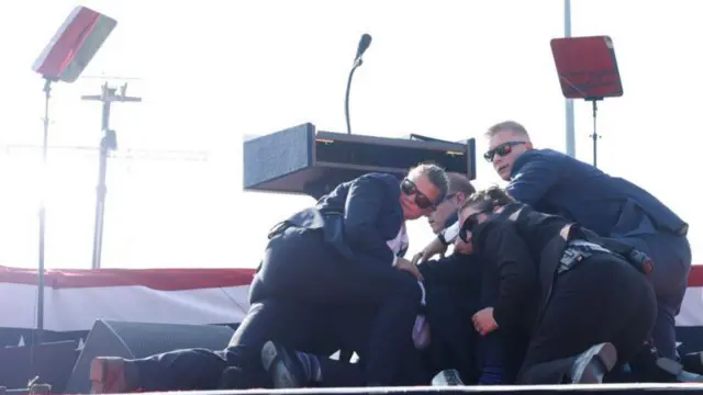 Members of the Secret Service surrounded Trump on stage immediately after the shooting