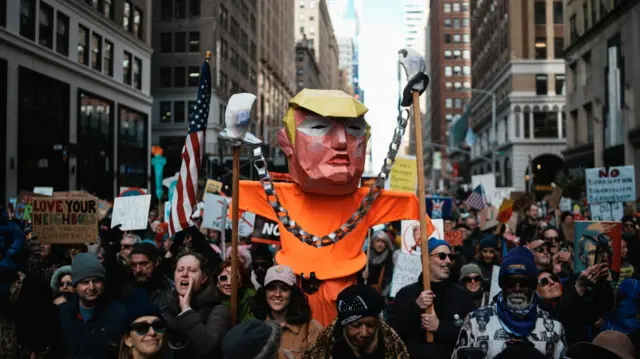 Manifestantes carregam uma figura representando o presidente dos Estados Unidos, Donald Trump, em Nova York
