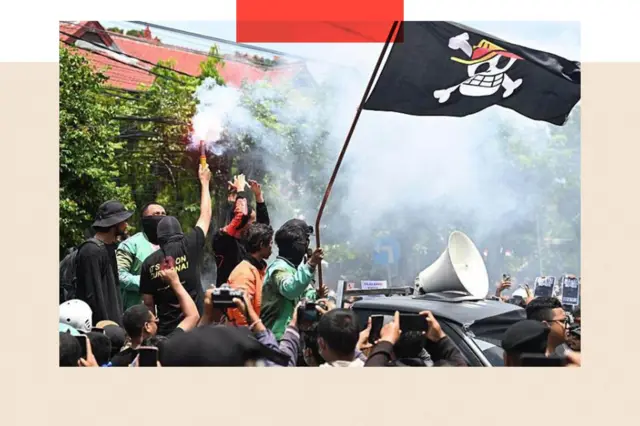 Waandamanaji wakiwa wameinua bendera yenye nembo ya fuvu la kichwa