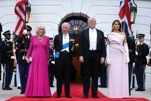 Soldan sağa Camilla, Kral Charles, trupm ve Melania trump. hepsi protokol kıyafetleriyle. arkada abd muhafızları var.