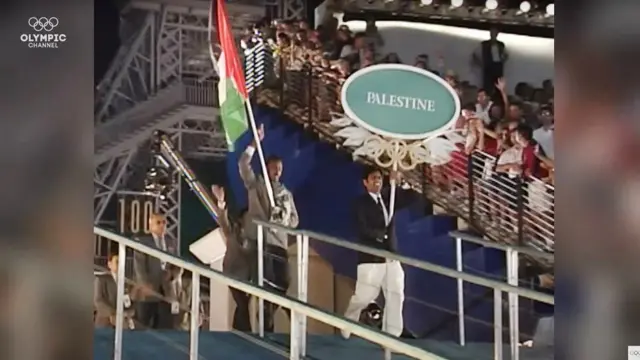 Majed Abu Maraheel, carregando a bandeira e liderando a delegação palestina