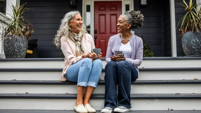 İki kadın merdivende oturup sohbet ediyor