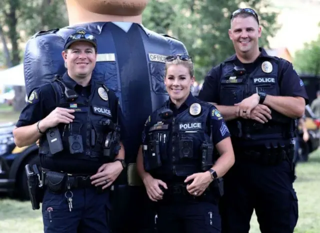 ضاباط يرتدون الزي الرسمي يلتقطون صورة في حديقة محلية بمدينة جولدن، كولورادو.