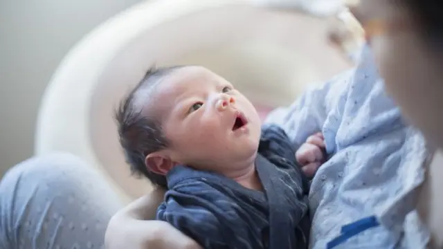 Bebê no colo olhando para a mãe