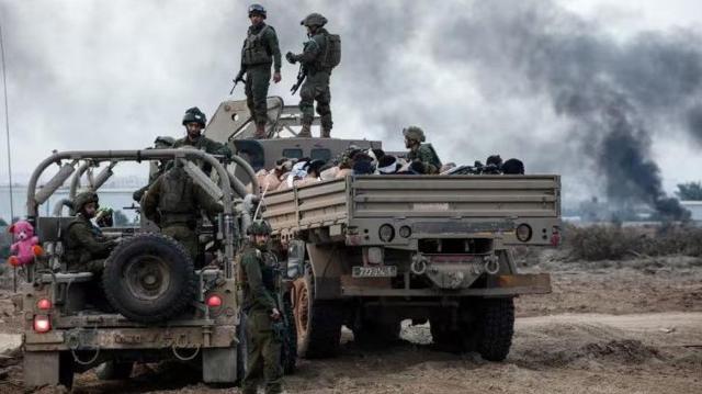 جنود إسرائيليون يقفون على شاحنة تنقل معتقلين فلسطينيين في غزة، في ديسمبر 2023