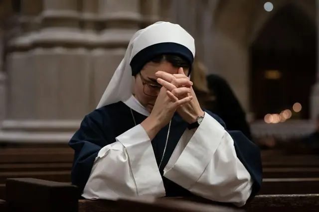 Wata hadimar coci na yi wa Fafaroma addu'a a cocin St Patrick da ke birnin New York na ƙasar Amurka