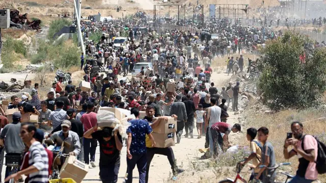 Люди несут коробки с гуманитарной помощью