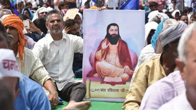 ਗੁਰੂ ਰਵਿਦਾਸ ਜੀ ਦੀ ਤਸਵੀਰ ਦੇ ਨਾਲ ਮੁਜ਼ਾਹਰੇ ਵਿੱਚ ਇੱਕ ਵਿਅਕਤੀ