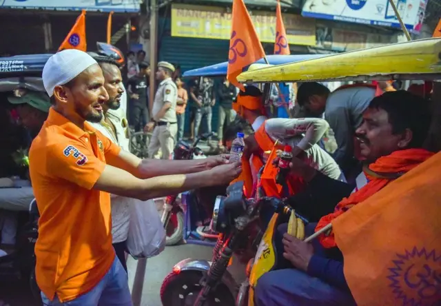 हिंदू श्रद्धालुओं को पानी देता मुस्लिम नौजवान