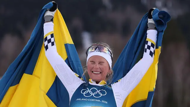 Фрида Карлссон из сборной Швеции празднует победу в женском скиатлоне 10 км + 10 км в первый день зимних Олимпийских игр Milano Cortina 2026 на стадионе для лыжных гонок Tesero 7 февраля 2026 года в Валь-ди-Фьемме, Италия.