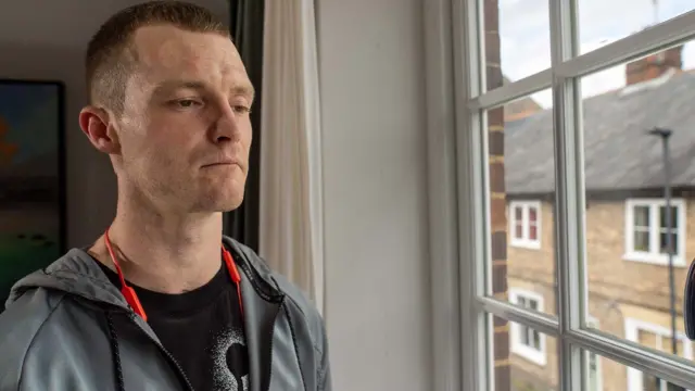 Jamie está ao lado de uma janela