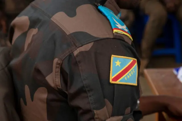 Un homme en uniforme avec le drapeau de la RDC