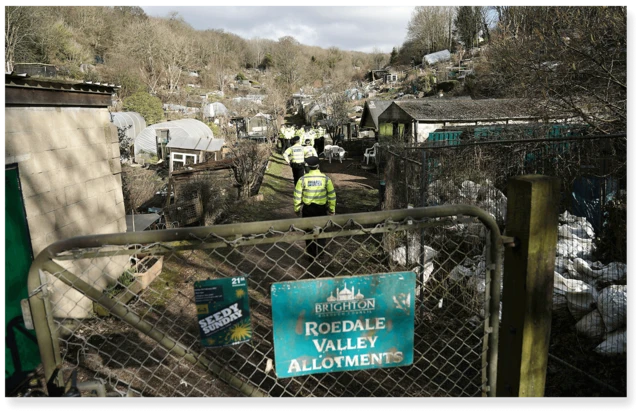 Policiais dentro de terreno cercado por grades, onde ficava o galpão