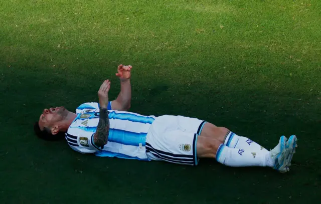 Messi tirado en el campo de fútbol.