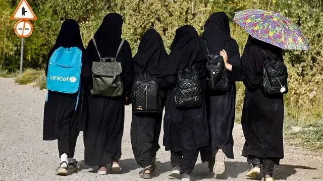 څو افغان نجونې په تور لباس کې ښوونځي ته ځي