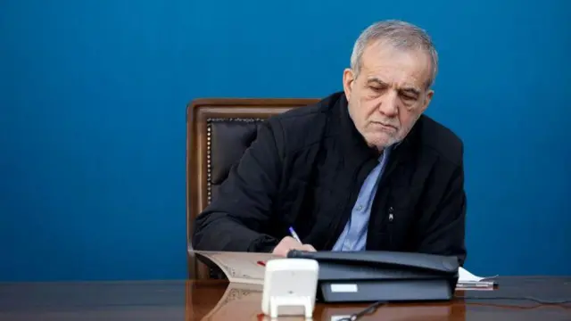 مسعود پزشکیان در حال امضای یک کاغذ