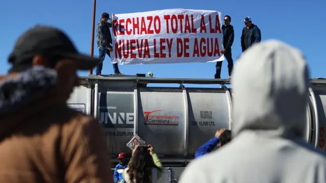 Camioneros que transportan mercancías de exportación a Estados Unidos sostienen una pancarta que dice "Rechazo total a la nueva ley del agua" durante una manifestación como parte de la huelga nacional de agricultores, en el Puente Internacional Zaragoza-Ysleta en Ciudad Juárez, estado de Chihuahua, México, el 24 de noviembre de 2025. (Foto de HERIKA MARTINEZ / AFP vía Getty Images)