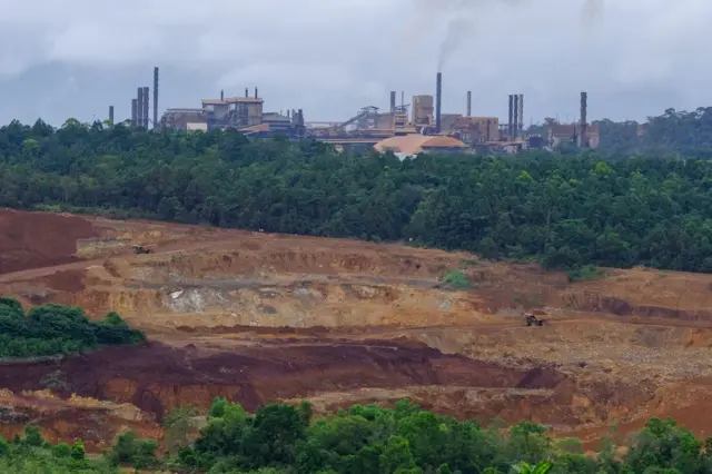 Sebuah foto udara menangkap salah satu pabrik smelter nikel yang ada di Indonesia dengan latar depan hutan yang sudah ditebangi.