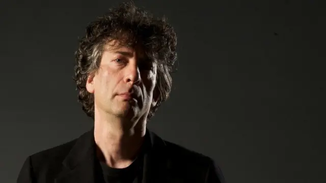 Neil Gaiman mais jovem, um homem brancocodigo de bonus betanocabelo nas orelhas e roupas pretas