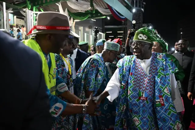 Foto Onyeisiala Tinubu dịka ọ na-ekene ndị otu pati APC bịara ọgbakọ ahụ
