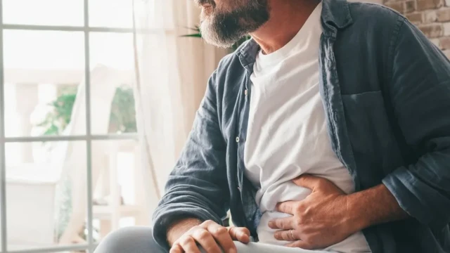 Homem com a mão na barrigaestrela bet app loginsinalestrela bet app logindesconforto