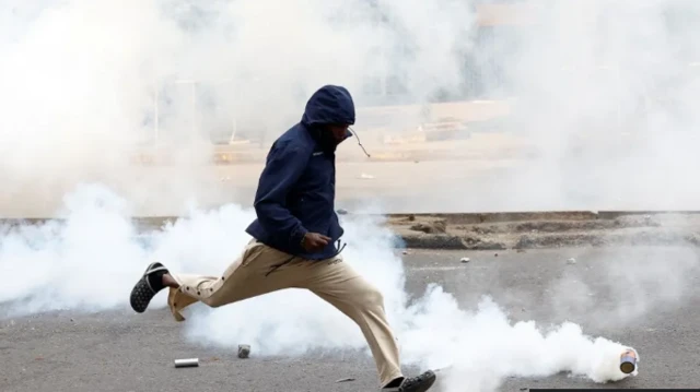 Wani mutum ya rufe kansa yayin da yake kwallo da gwamgwanin hayaki mai sa hawaye