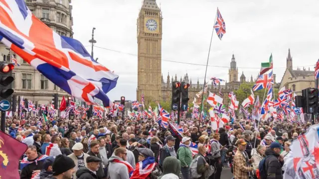 ビッグベンや議事堂の前の路上に、イギリスやイングランドの旗を手にした大勢が集まっている