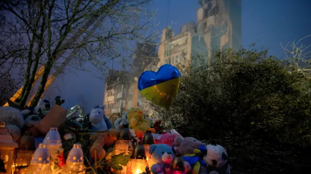 Znicze zapalone przed blokiem mieszkalnym, który został trafiony rosyjskim pociskiem rakietowym w trakcie ataku Rosji na Ukrainę