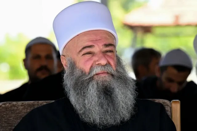 شیخ یوسف جربوع با ریشی خاکستری و کلاه سفید