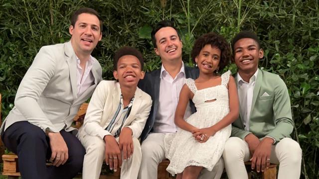 Carlos e Lucas, dois homens brancos, e os filhos do casal, três crianças negras