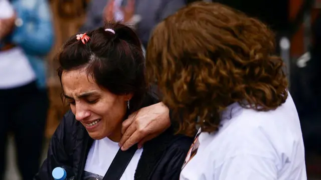 Duas mulheres chorando em meio a uma manifestação