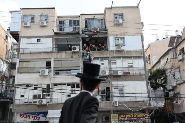 човек гледа у зграду погођену у иранском нападу