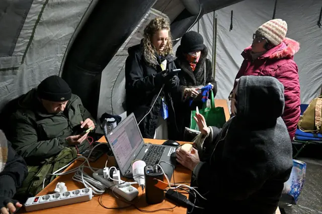 Люди гріються у наметі 