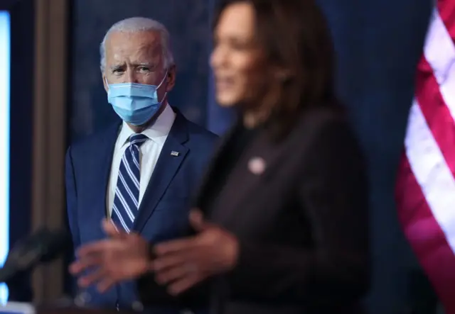Joe Biden mira desde lejos a Kamala Harris mientras ofrece un discurso