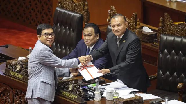 Wakil Ketua Badan Legislasi (Baleg) DPR Achmad Baidowi (kiri) menyerahkan berkas laporan pembahasan RUU Kementerian Negara kepada Wakil Ketua DPR Lodewijk Freidrich Paulus (kanan) dalam Rapat Paripurna, Kamis (19/09).