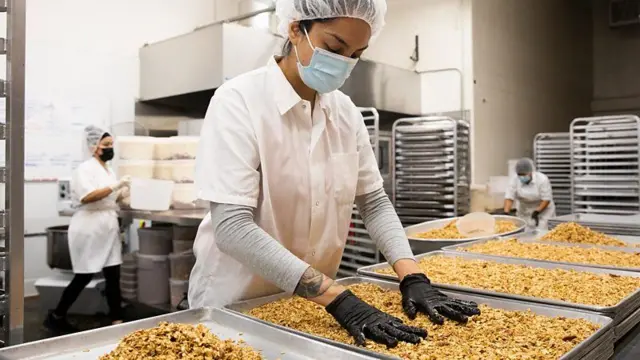 Funcionárias em fábrica de produção de granola lidam com o produto