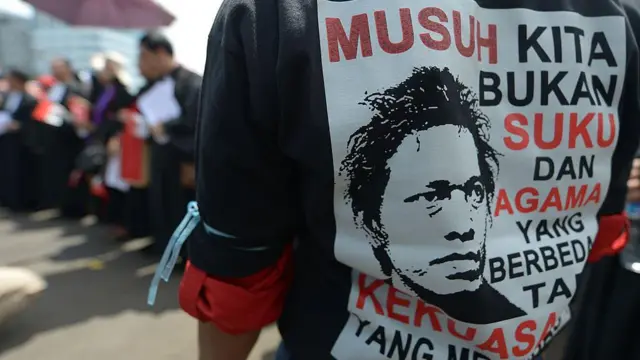 Seorang demonstran mengenakan kaos bertuliskan, "Musuh kita bukanlah keberagaman agama atau ras, tetapi pemerintah yang menindas".