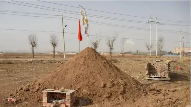 Sebuah kuburan baru di lahan pertanian sebuah desa terpencil di China.