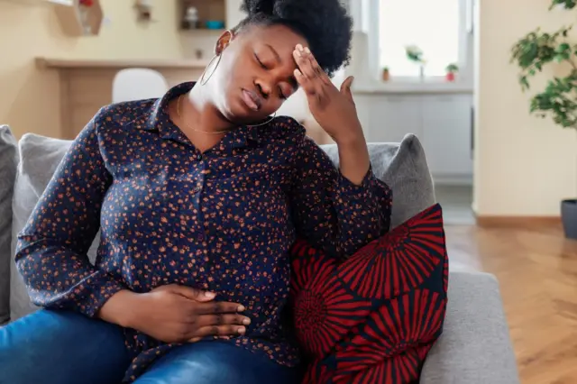 Une femme se tordant de douleur.