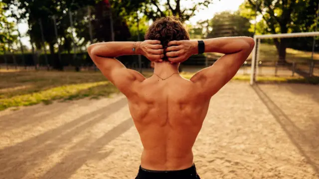 Un joven con espalda musculosa posa ante las cámaras.