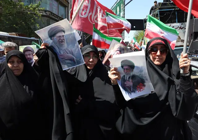 افرادی در تهران در تجمعی برای کشته شدن علی خامنه‌ای، تصاویر او را در دست دارند
