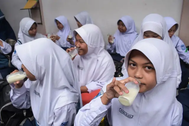 Para siswa minum susu sambil menyantap makan siang pada hari pertama program makan gratis di SMP Negeri 12 Cimahi, Jawa Barat, pada 6 Januari 2025.