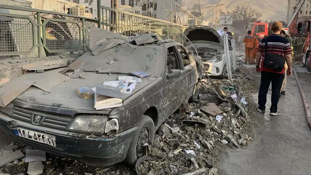 A view of damaged vehicles in the Iranian capital, Tehran, following an Israeli attack, on June 13, 2025. Firefighting teams are dispatched to the area