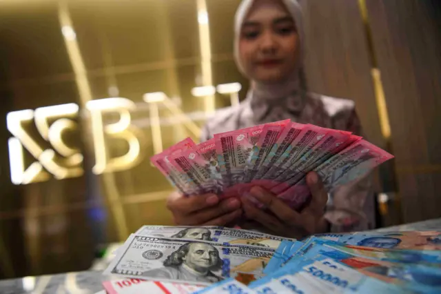 Petugas menunjukkan pecahan mata uang Rupiah dan Dolar Amerika Serikat (AS) di Kantor Cabang BNI Pasar Baru, Jakarta, Kamis (15/1/2026). Nilai tukar rupiah kembali ditutup melemah mencapai posisi Rp16.885 per Dolar AS atau tergerus 0,15 persen pada perdagangan Kamis, 15 Januari 2026. 
