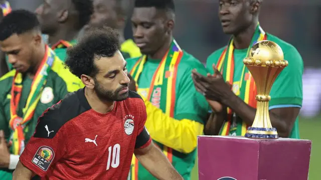 Salah passe devant le trophée de la Coupe d'Afrique des nations 