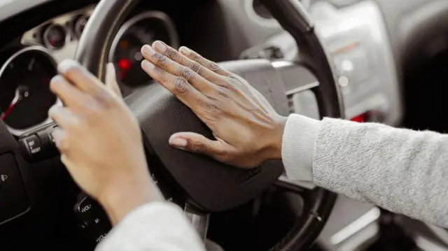 Pessoa apertando a buzinaaplicativo que aposta e ganha dinheiroum carro