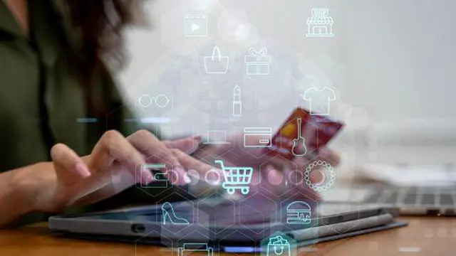 Жінка пише на планшеті, тримає банківську картку