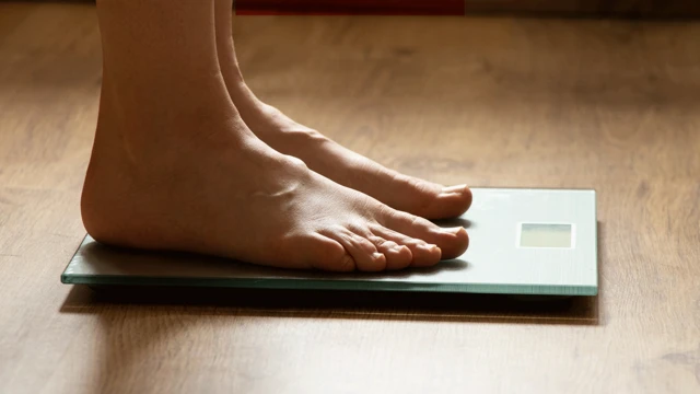 Людина стоїть на вагах, фото в профіль